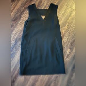 Black dress to the knees with satin accent around neck. With Pockets